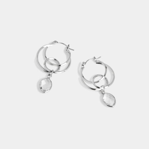 Silver hoop earrings with teardrop-shaped charms on a white background