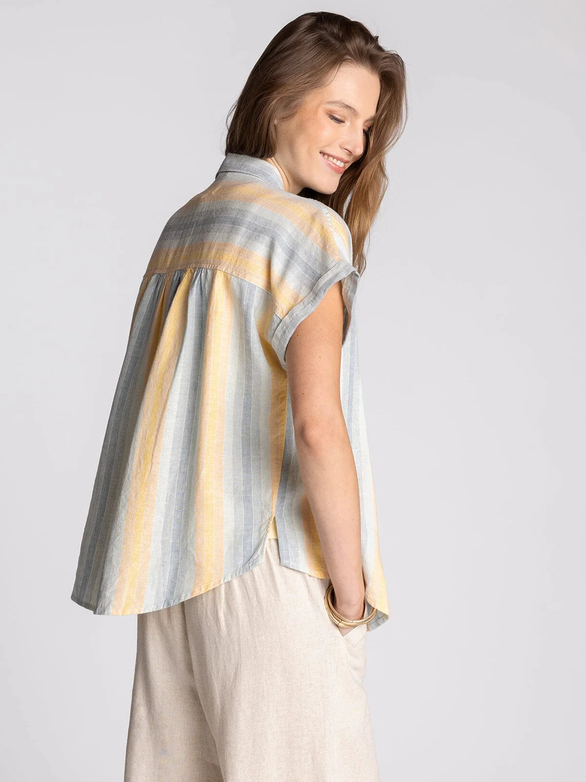 Woman wearing Benny striped linen blend button-up shirt with soft multicolor vertical stripes back view