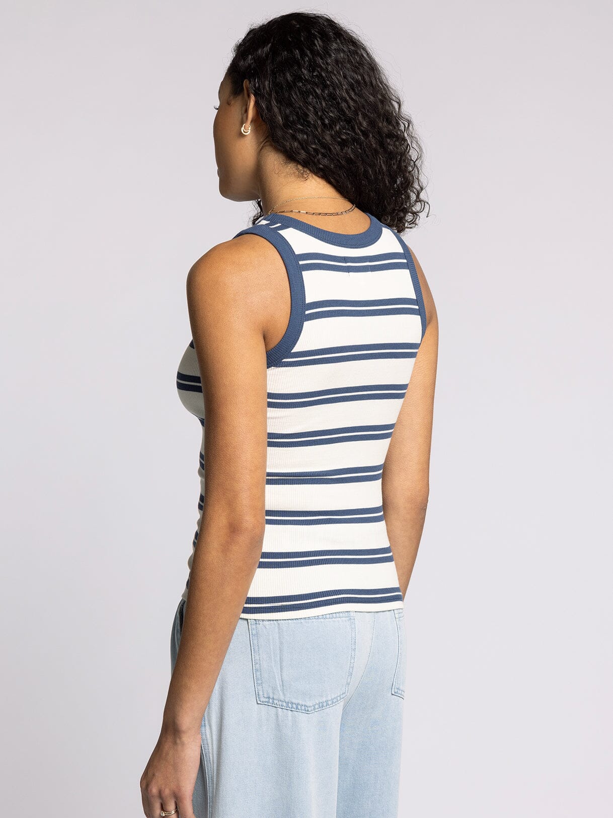 woman wearing fitted white and indigo striped ribbed tank top with contrast trim back view