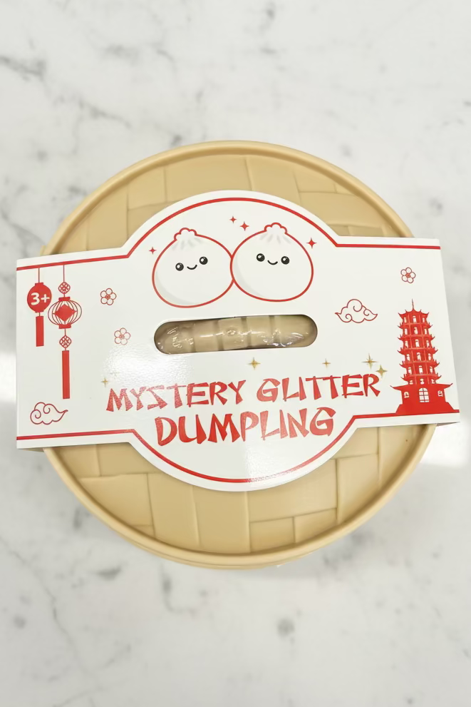 Mystery glitter dumpling squishy sensory toy in container with sparkly surprise color