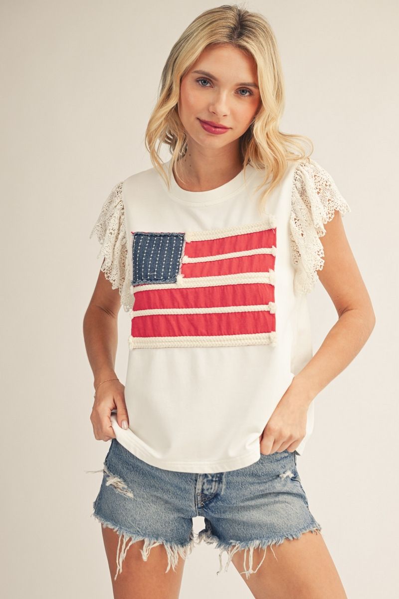 woman wearing off white patriotic top with lace flutter sleeves and American flag patch