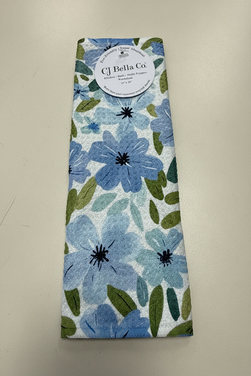 Light Blue Blooms eco-friendly waffle weave washcloth featuring watercolor blue flowers and green leaves on a white background.