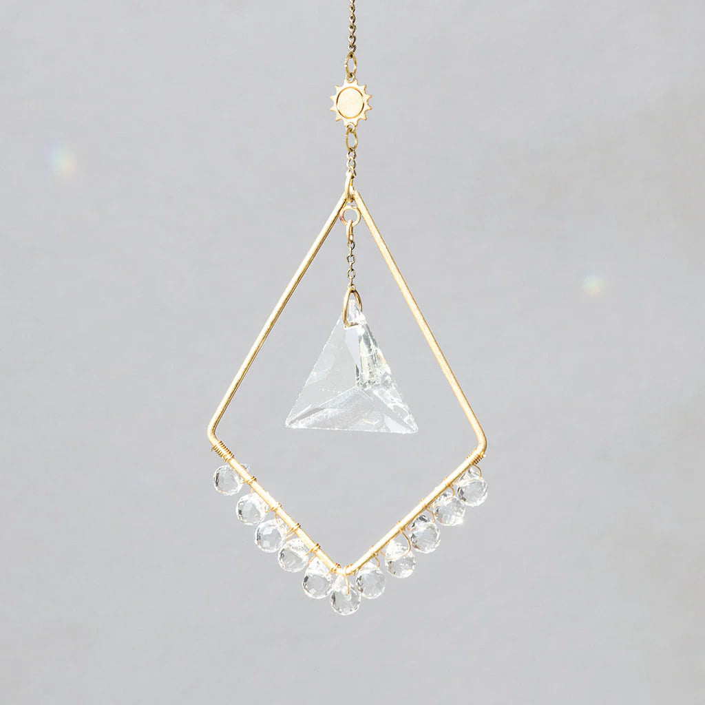 Scout Curated Wears Sun Harmony mini crystal suncatcher featuring gold-plated brass frame and crystal prism creating rainbow reflections