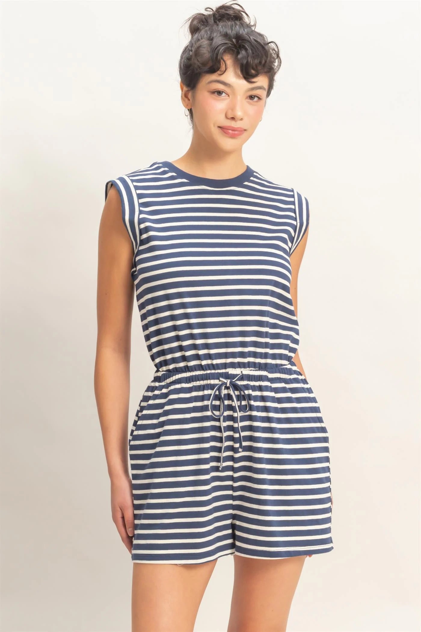 woman wearing navy striped sleeveless romper with drawstring waist and pockets
