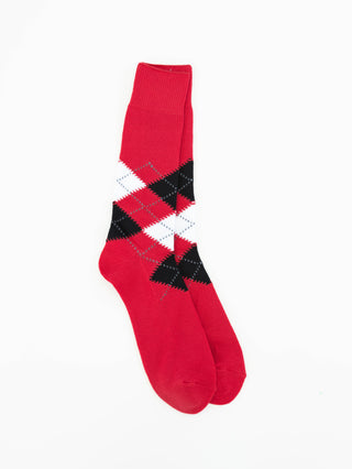 A pair of red crew socks with an argyle pattern in black, white, and gray, displayed against a plain white background.