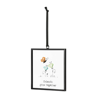 Friends Grow Together Suncatcher by DEMDACO — full view of the square black metal floating frame showing the sea glass butterfly and two sea glass flowers with "friends grow together" sentiment, hung by a black grosgrain ribbon against a white background
