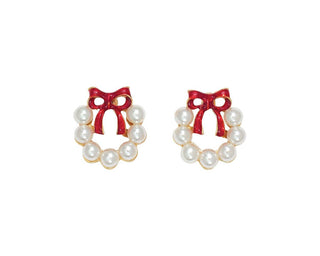 A pair of gold-tone stud earrings shaped like small wreaths, each decorated with white faux pearls and a glossy red bow on top, shown on a plain white background.