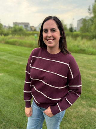 Person wearing a plum striped long sleeve sweater from Staccato.
