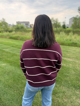View of back of plum striped long sleeve sweater from Staccato.