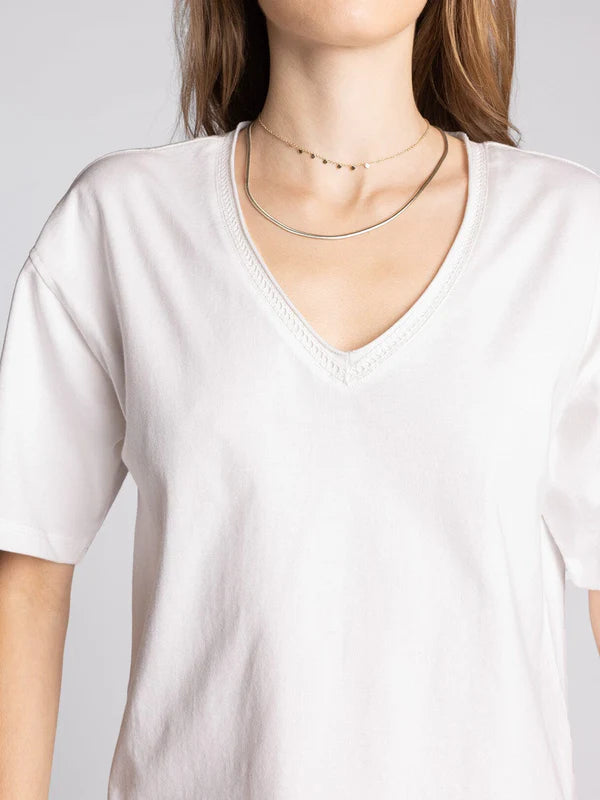 Tee in white — women's relaxed V-neck cotton t-shirt with raw-edged collar seaming close view of neck detail