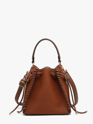 A brown leather bucket bag with a top handle, braided leather straps, and a detachable shoulder strap, shown against a plain white background.