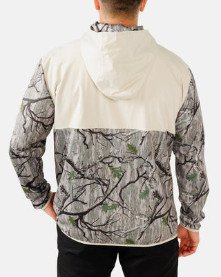 Back view of Waggle Men's Zenith Half-Zip Hoodie in Treed It — cream upper back with tree branch camo lower body and hood