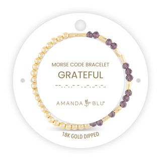Morse code bracelet with purple and gold beads on a white background