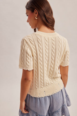 woman wearing cream American flag cable knit sweater with short sleeves back view