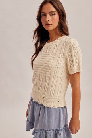 woman wearing cream American flag cable knit sweater with short sleeves side view