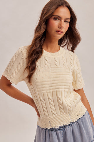 woman wearing cream American flag cable knit sweater with short sleeves