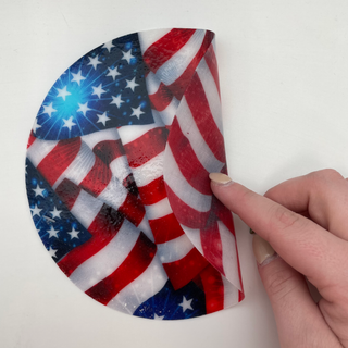 Hand holding Silicone Jar Opener with American flag design on a white background