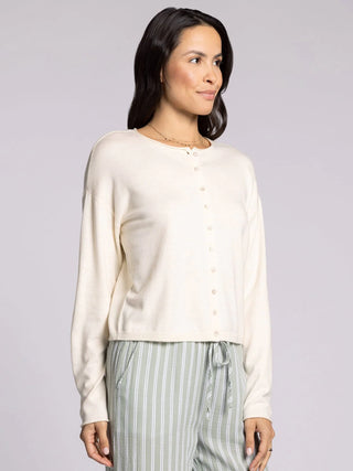 Woman wearing ivory cropped knit cardigan sweater with button front and relaxed fit