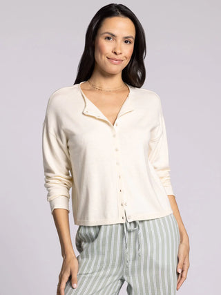 Woman wearing ivory cropped knit cardigan sweater with button front and relaxed fit