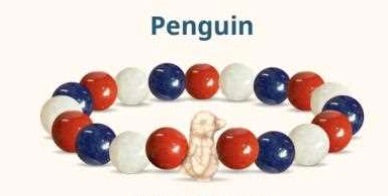 Bracelet with red, blue, and white beads featuring a small penguin figure on a white background.