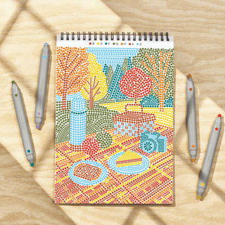 Sample page of FlowArt Sweater Weather with a colorful mosaic design on a wooden surface with pens.