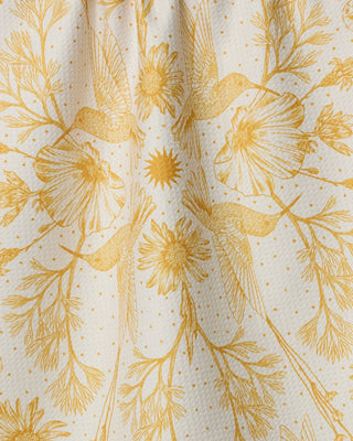 Geometry Gilded Nectar kitchen tea towel featuring gold hummingbirds and wildflowers on an ivory background with quick-drying Geoweave™ fabric.
