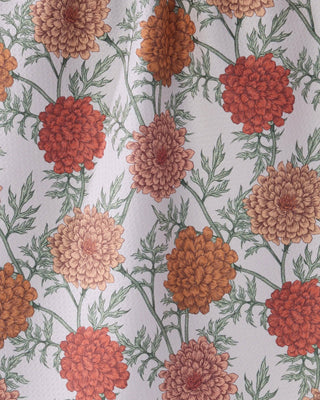 Close-up of Geometry Marigold Manor Tea Towel showing Geoweave™ fabric texture with detailed botanical illustration of marigold blooms in terracotta, rust, orange, and blush tones on recycled polyester