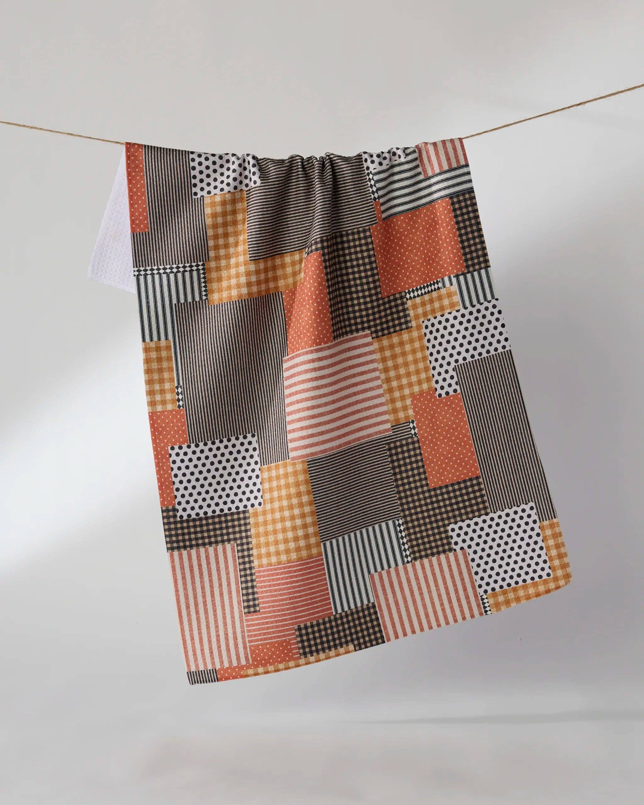 Geometry Patch and Pumpkin Tea Towel — autumn patchwork Geoweave™ kitchen towel with orange, brown, beige, and white stripes, polka dots, and gingham, 18x30 inches
