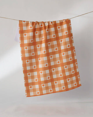 Geometry Pumpkin Check Tea Towel — orange and white gingham check Geoweave™ kitchen towel with small orange pumpkin overlay, 18x30 inches, made from recycled materials
