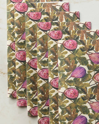 Close-up of Geometry Wild Fig Not Paper Towel set of 6 on white marble showing detailed botanical illustration of sliced pink figs and whole purple figs among earthy green leaves on Geoweave™ fabric