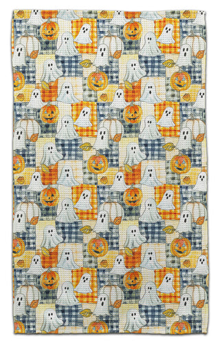 Eco-friendly towel with an all-over Halloween pattern featuring white ghosts, orange pumpkins, and blue-and-white plaid squares on a cream background.
