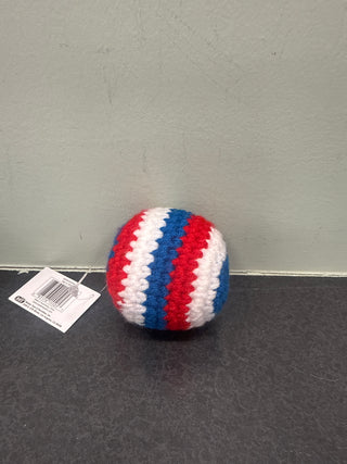 Crocheted kick sack with red, white, and blue stripes on a gray surface
