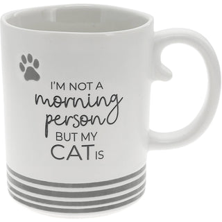 White 15 oz ceramic coffee mug featuring the funny saying "I'm Not a Morning Person But My Cat Is" with gray paw print accents.
