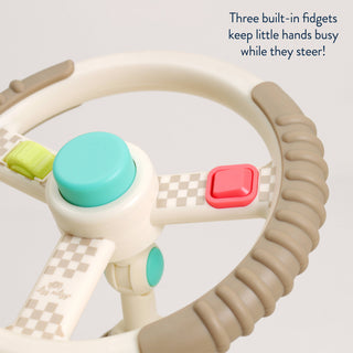 Toy steering wheel with buttons and text on a light gray background