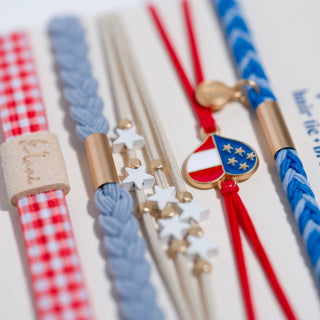 K’lani Free patriotic hair tie bracelet set in red, white and blue with USA heart charm and gingham accent close up view