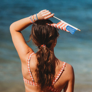 Women wearing K’lani Free patriotic hair tie bracelet set in red, white and blue with USA heart charm and gingham accent