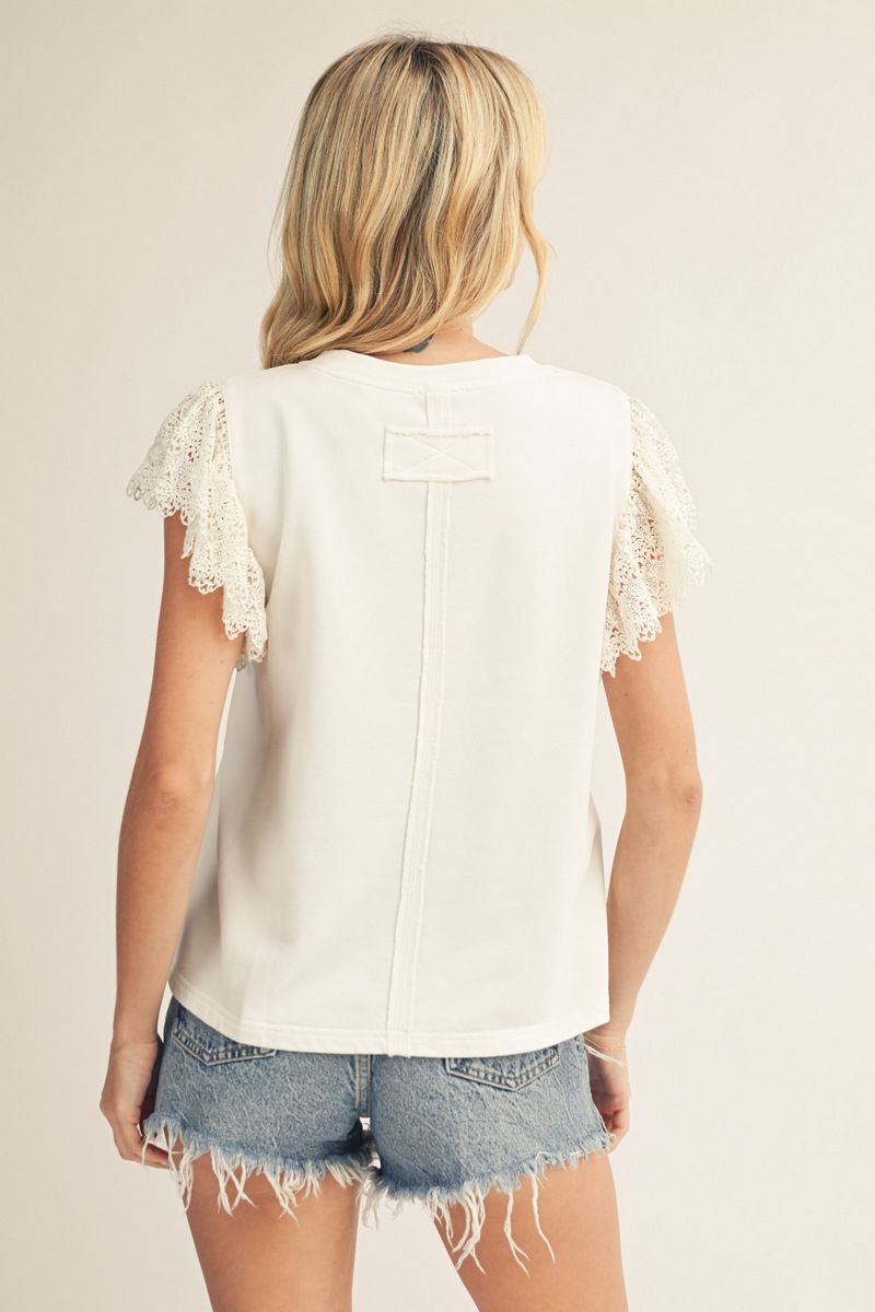 woman wearing off white patriotic top with lace flutter sleeves and American flag patch back view