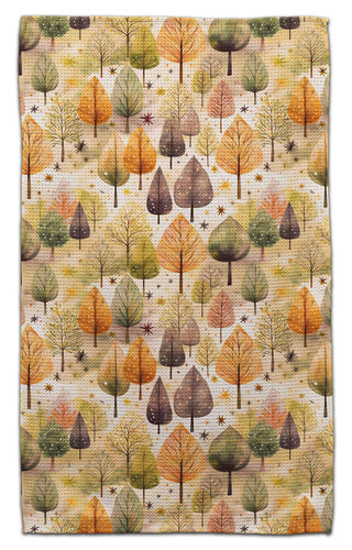 Eco-friendly towel featuring an all-over autumn forest pattern with trees in shades of orange, yellow, green, and brown on a cream background.