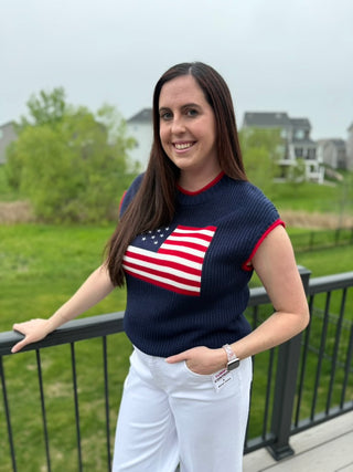 woman wearing navy sweater vest with American flag and red trim detail