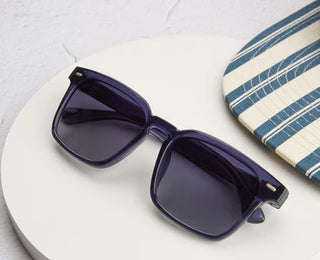 Peepers Shasta Polarized Sunglasses in Blue featuring bold square frames, gold pin accents, and smoke gradient polarized lenses.