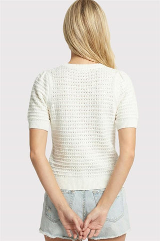 woman wearing a white pointelle short puff sleeve lightweight sweater back view
