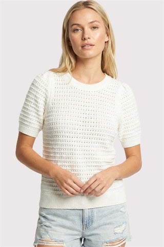 woman wearing a white pointelle short puff sleeve lightweight sweater