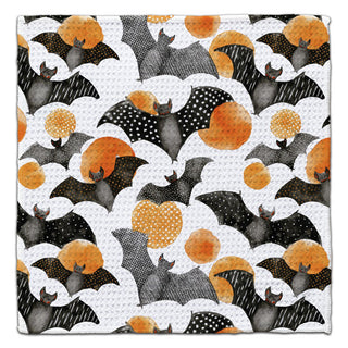 Eco-friendly washcloth featuring a repeating Halloween pattern of bats and polka dots in black, gray, orange, and white.