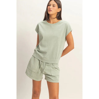 woman wearing sage green cotton sleeveless top and matching shorts set with pockets front view