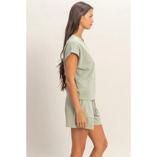 woman wearing sage green cotton sleeveless top and matching shorts set side view