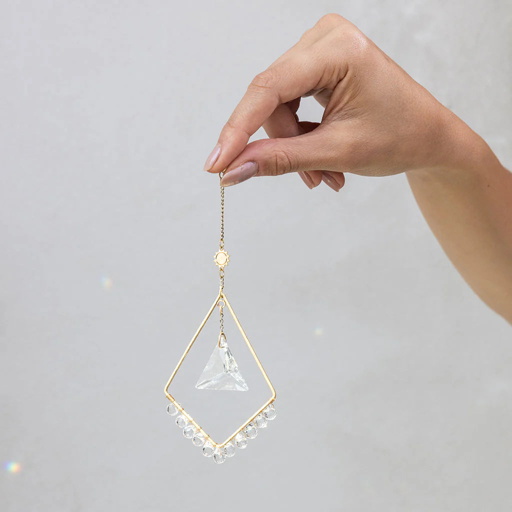 Scout Curated Wears Sun Harmony mini crystal suncatcher featuring gold-plated brass frame and crystal prism creating rainbow reflections