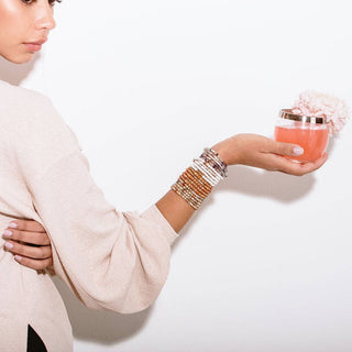 Woman wearing multiple bracelets on a white background