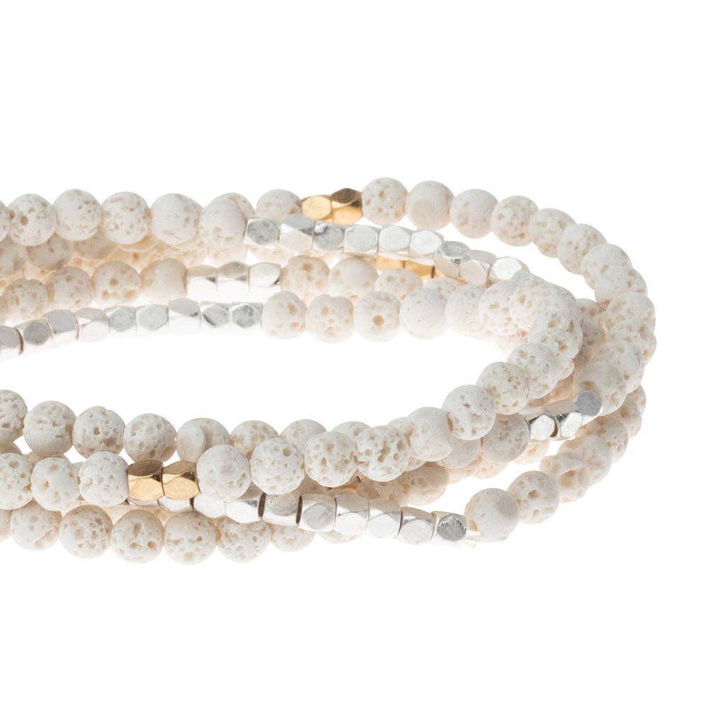 White beaded bracelet with gold accents on a white background