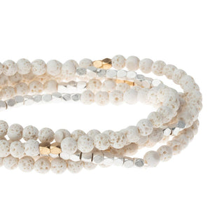 White beaded bracelet with gold accents on a white background