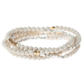 White beaded bracelet with gold accents on a white background